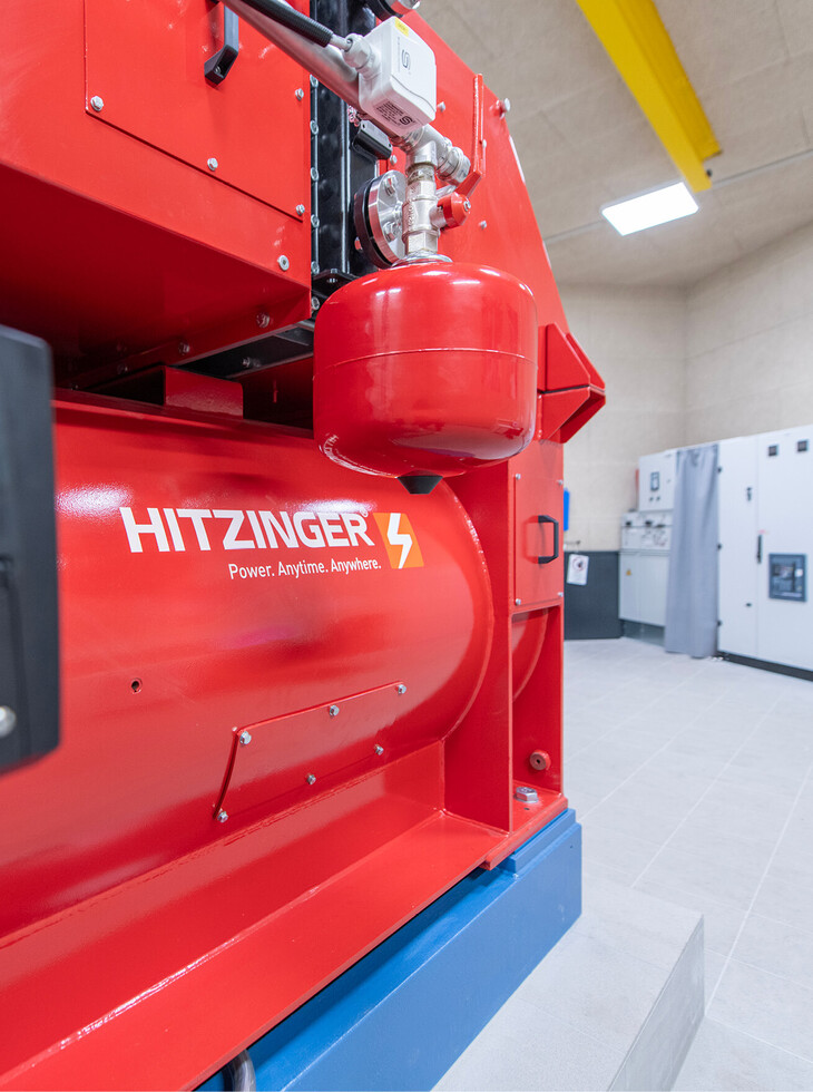 Close-up of a red hydroelectric power plant with a pressure vessel in a technical room.