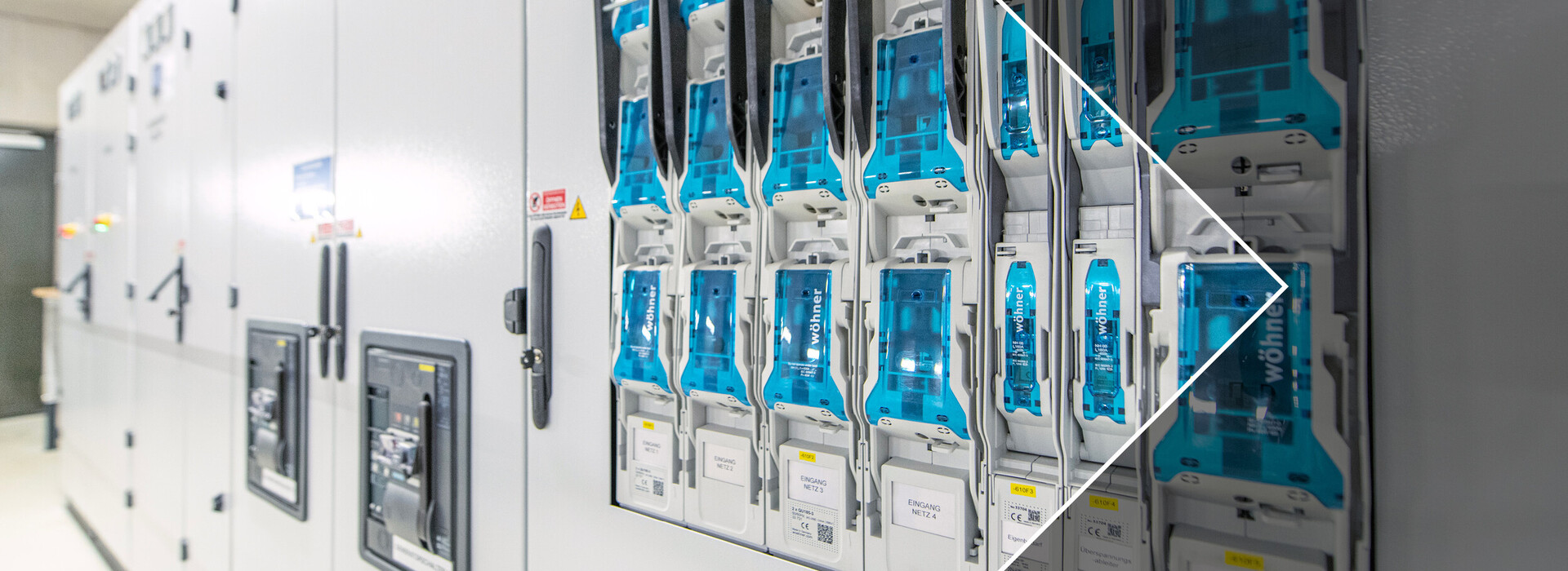 A row of electrical meters in a white control cabinet.