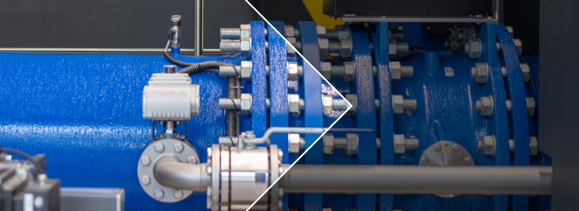 Close-up of a blue turbine with flange connection and several screws in an industrial plant.
